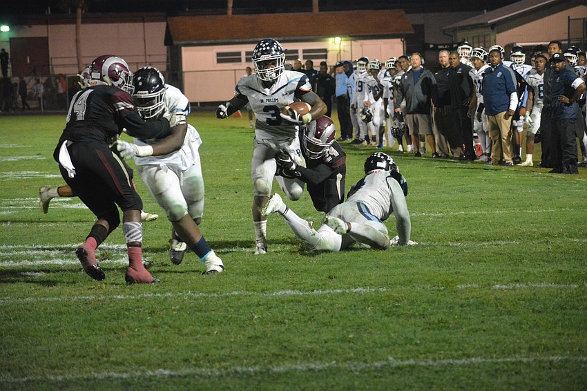 Senior Saul Johnson (24) grabs a Dr. Phillips running back by the leg, but cannot bring him down.