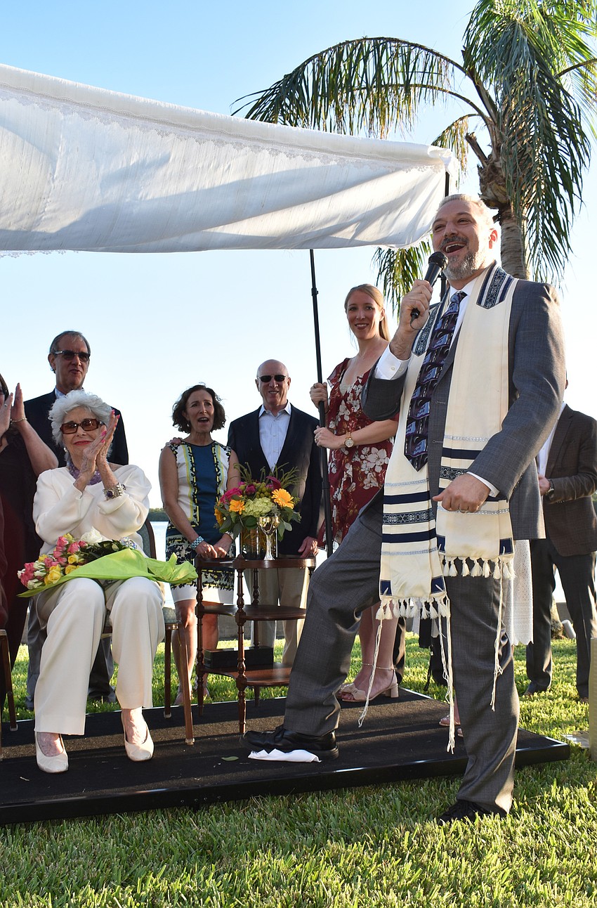 Rabbi Michael Shefrin breaks the ceremonial glass, which, in the Jewish tradition, serves as a reminder that even in joyous moments, there are still broken things in the world that need mending.