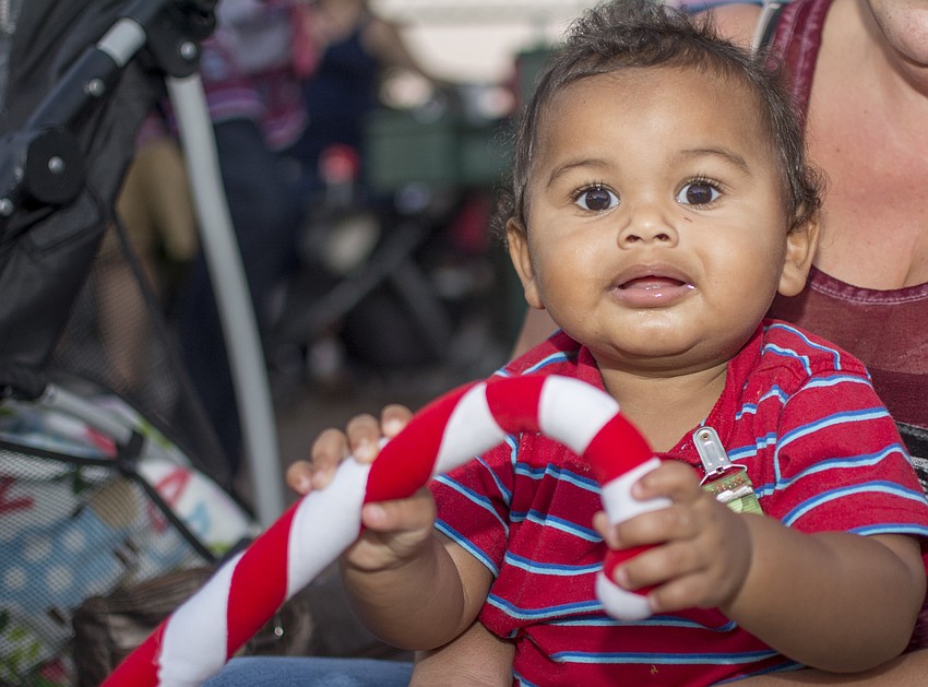 Emanuel Lefresne sits on the curb along Ocean Boulevard before the Siesta Key holiday parade.