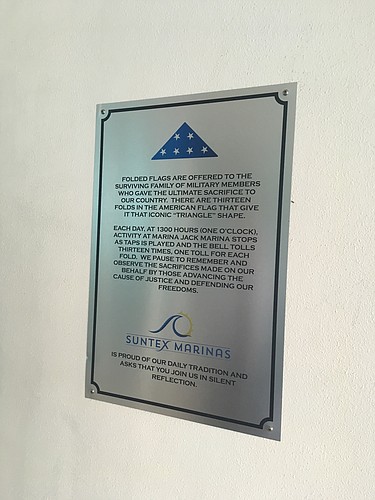 A plaque near the entrance to Marina Jack explains the significance of the daily playing of taps.
