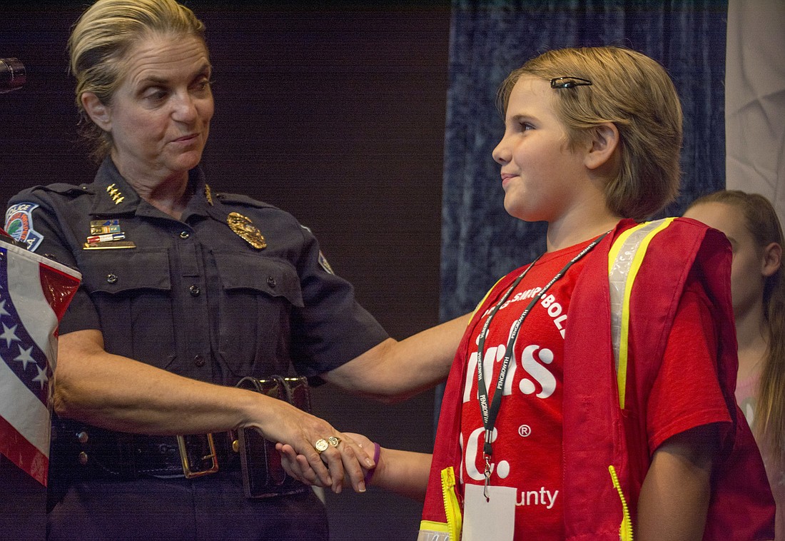 Sarasota Police ChiefÂ Bernadette DiPino shakes hands with Sloan after swearing her into office.