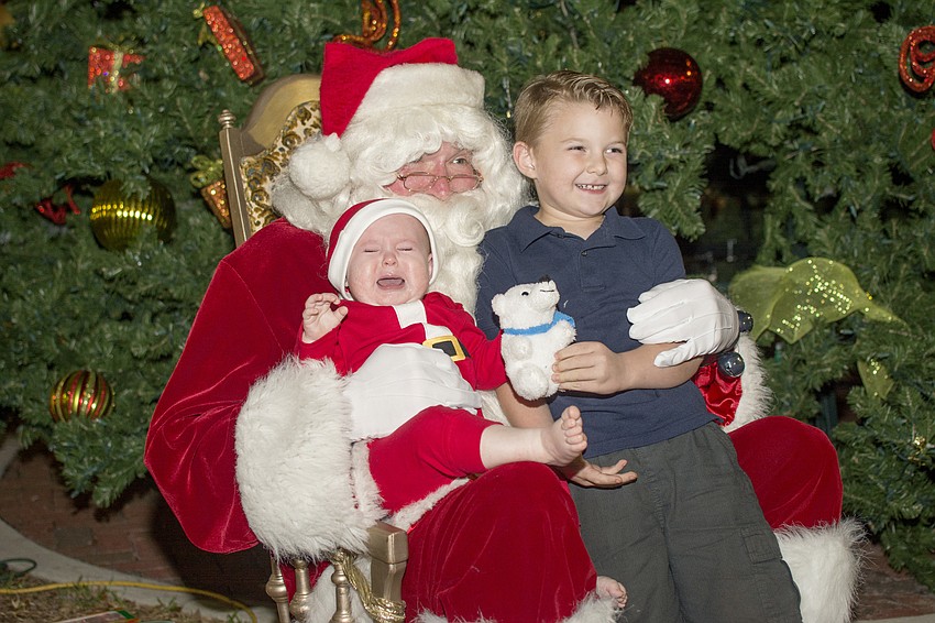 Kye and Silas Daughtrey pose with Santa at the downtown tree lighting celebration.