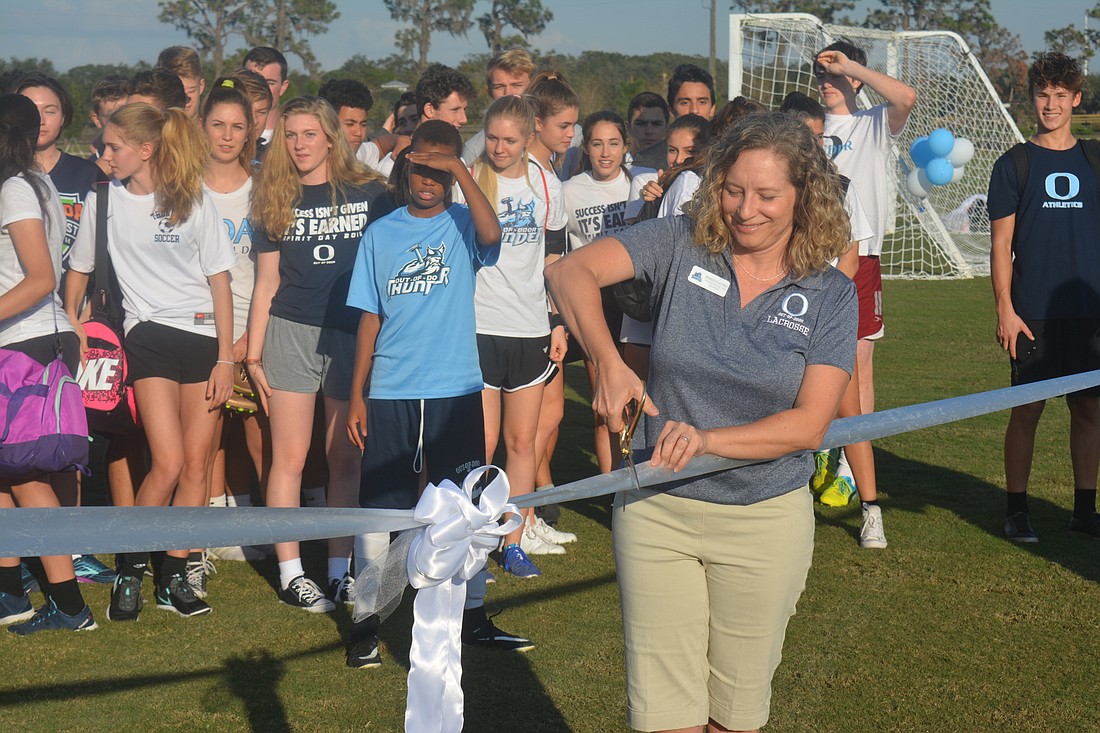 Nancy Castro cuts the ribbon to open The Out-of-Door Academy&#39;s new practice facility.