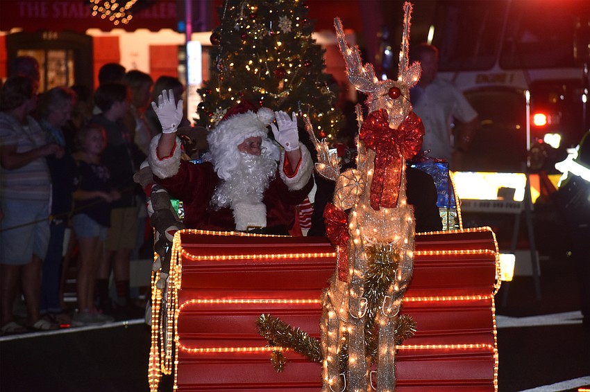 Santa Claus waves to the crowd as he arrives at St. Armands Circle.