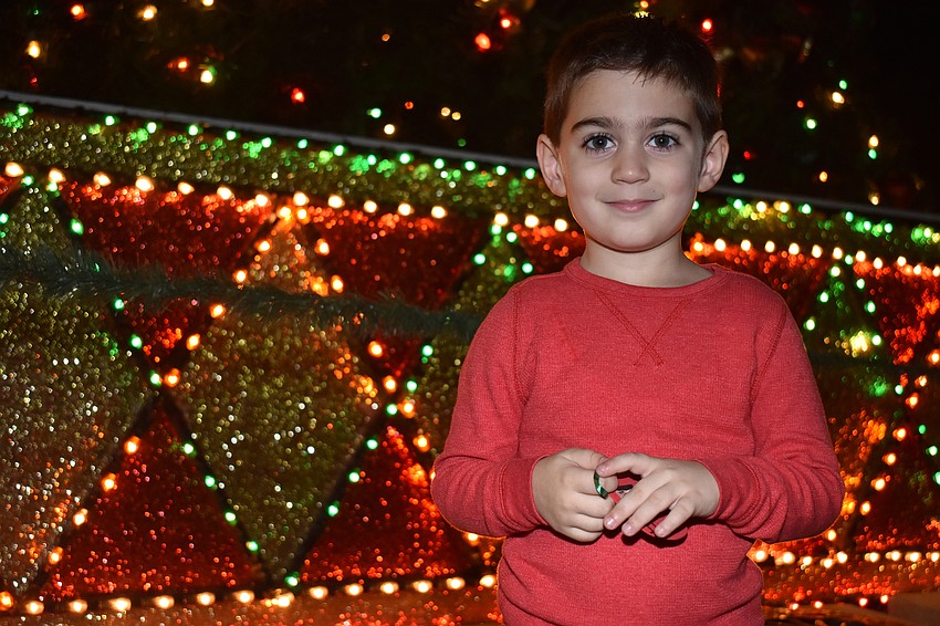 Daniel Yzeiri poses next to the Christmas tree.