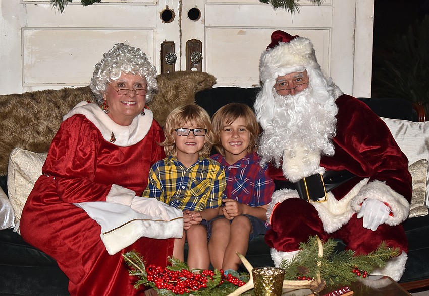Daniel and Walter Zach pose with Santa and Mrs. Claus.