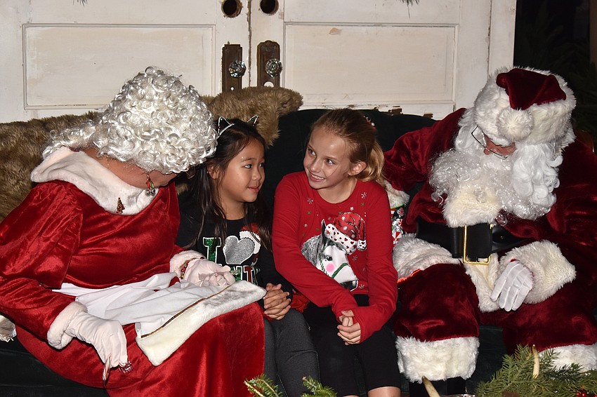 Lana Tran and Colleen Putnam share their Christmas lists with Santa and Mrs. Claus.