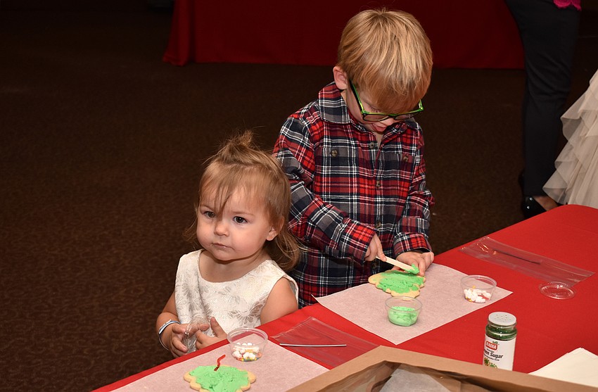 Stella and Porter McCoy decorate Christmas cookies.