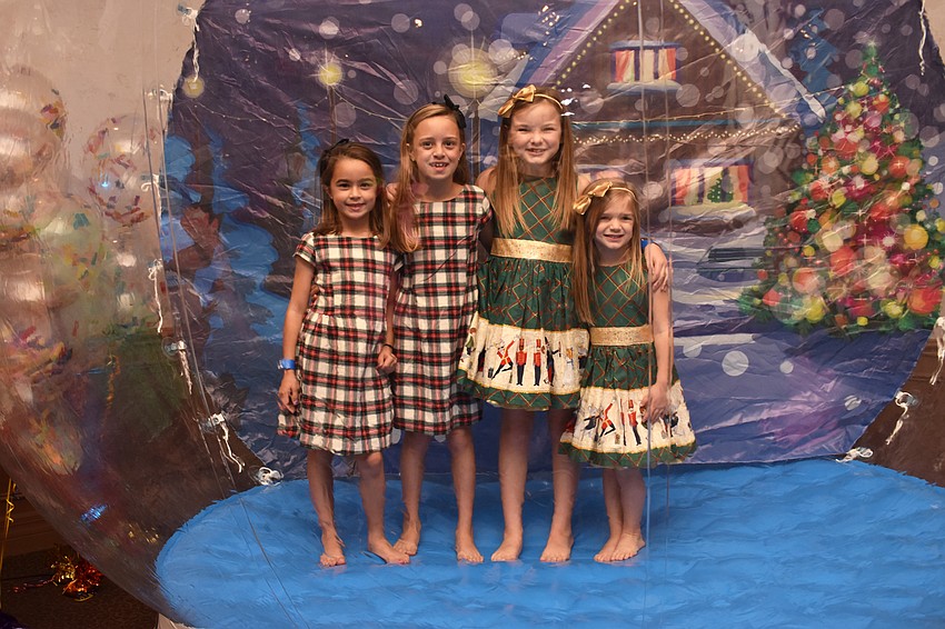 Ella and Avery Hunt and Olivia and Emma Gambert pose in the blow-up snow globe.