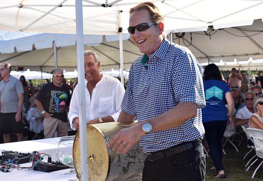 Congressman Vern Buchanan pulls the winning ticket for the cash prize of $20,000.