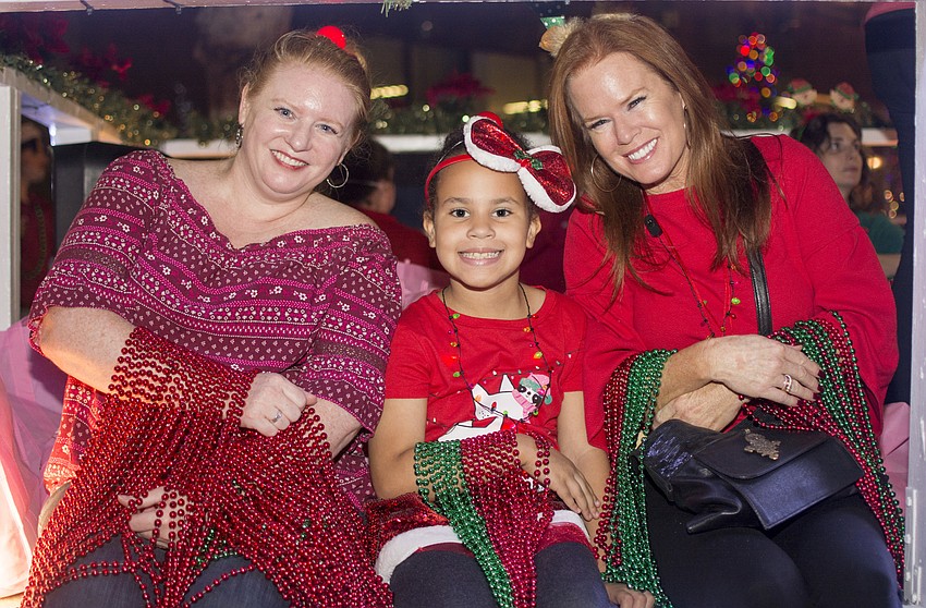 Jennifer Carvalho, Nevaeh Crews and Terri Klauber wait for the parade to begin on the Make-A-Wish float.