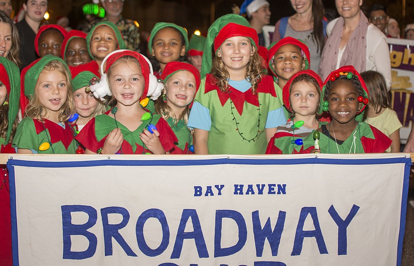 Members of Bay Haven Elementary School's Broadway Club pose with their banner before marching in the downtown Sarasota holiday parade.