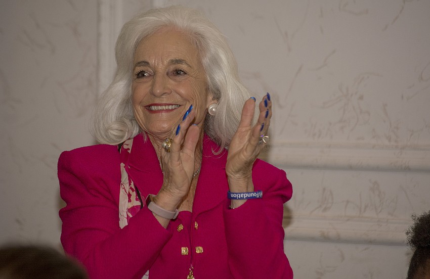 Graci McGillicuddy applauds the Embracing Our Differences staff and board members during its annual luncheon.