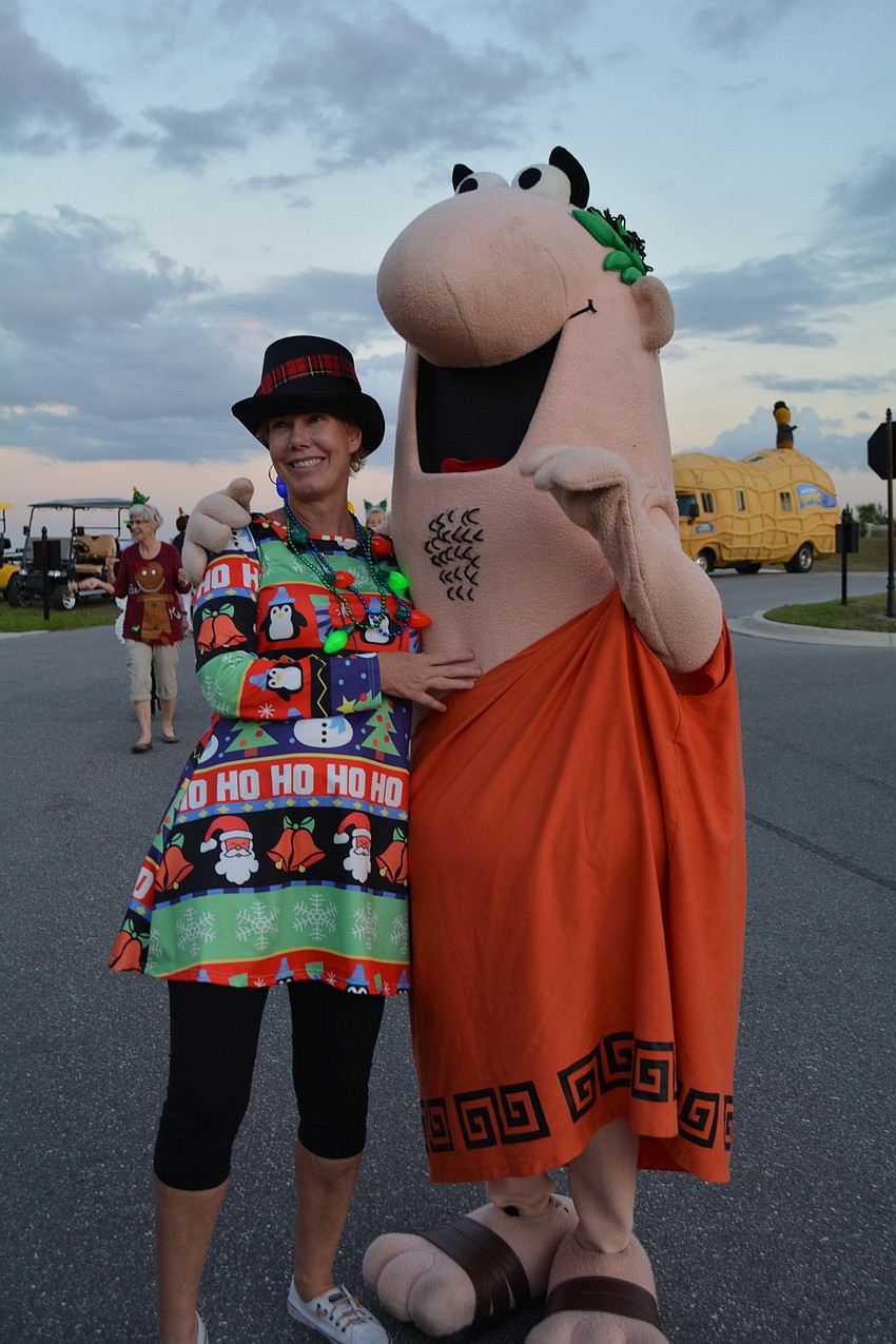 Joyce North, who organized the golf cart parade participants, makes sure to get a photo opportunity with Little Caesar.