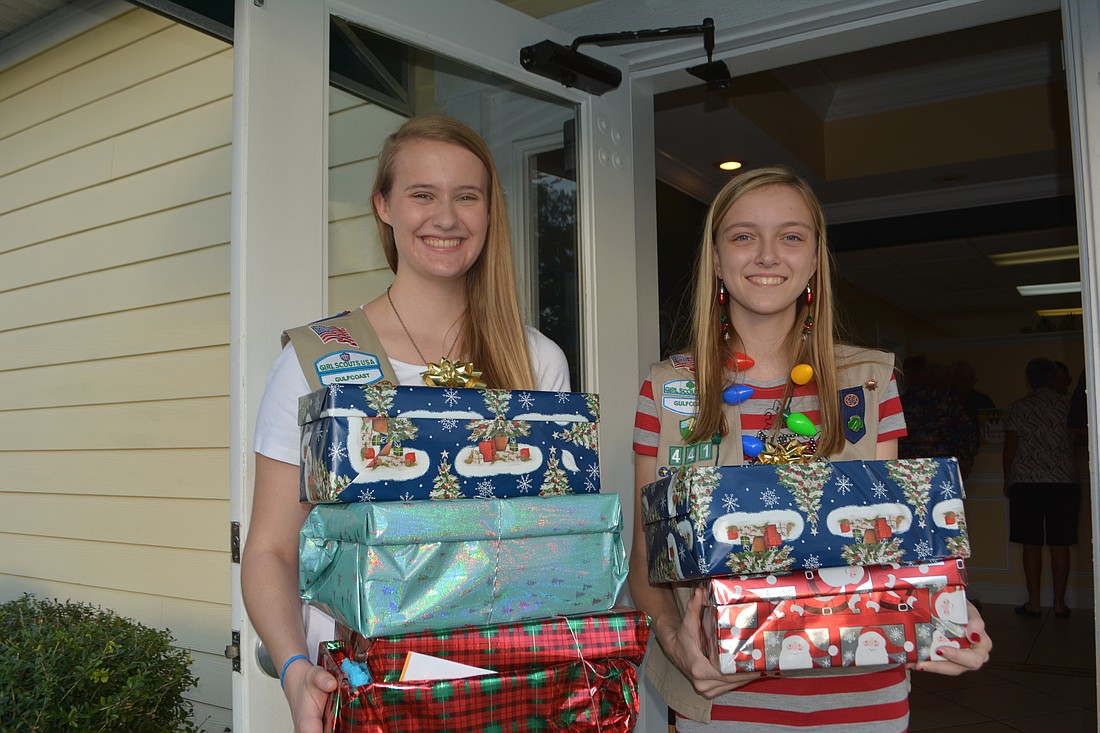 Cypress Potter, 18, and Sydney Graham, 14, collect gifts for seniors at the Shoe Box Reception. They represent Troop 441.