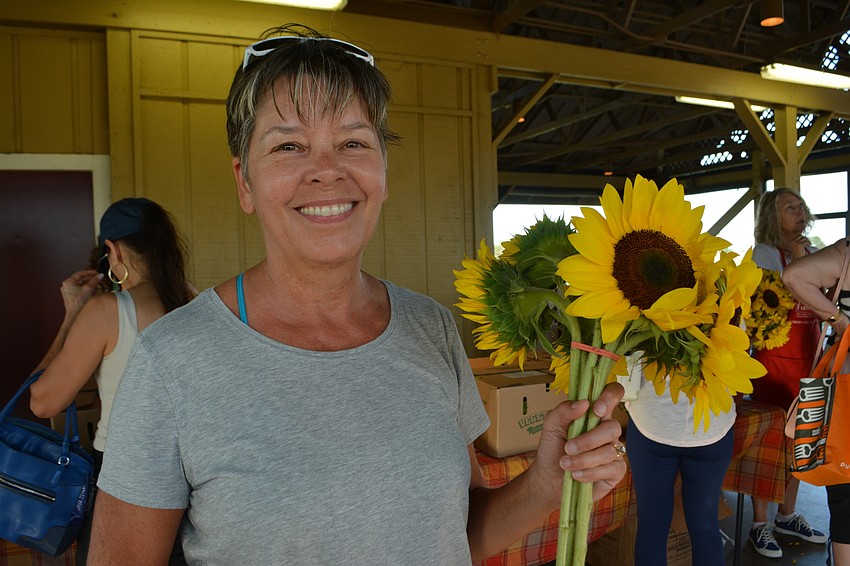 Becky LeVesque of Central Park shows off the sunflowers she picked up at The Market at Lakewood Ranch.