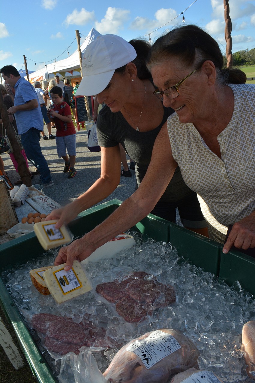 Visiting Bonnie Burchwell of Cincinnati and Kim Grimme of Lakewood Ranch check out the offerings from Grove Ladder Farm.
