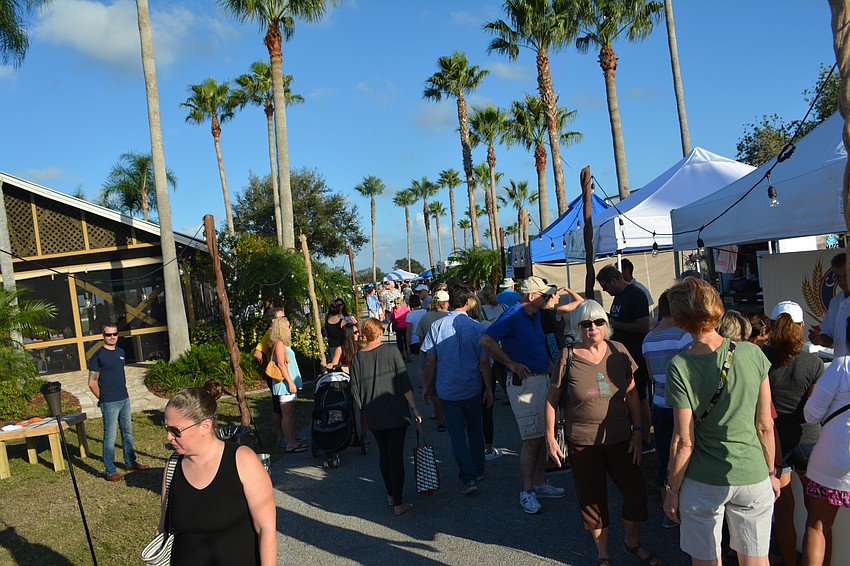 A crowd of people pack into a walkway at the Sarasota Polo Club during The Market at Lakewood Ranch.