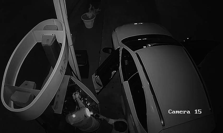 Screenshot of suspects installing a skimming device in a pump at the Longboat Key Mobile station.