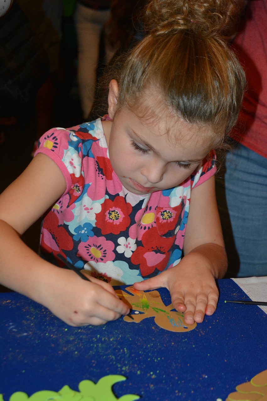 Julia Chandler, 4, of East County puts the finishing touches on a gingerbread man.