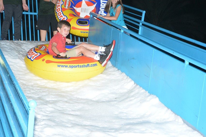 Sarasota's Bryson Taylor, 9, begins his slide down real snow on Lakewood Main Street.