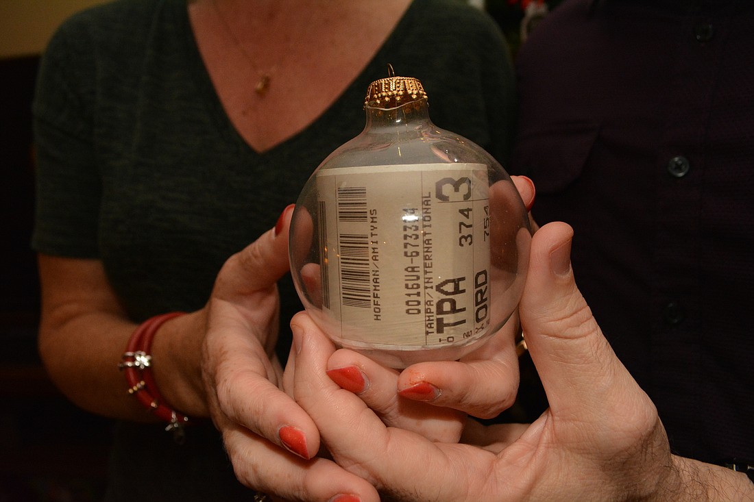 Tony Dertouzos and his wife, Amity Hoffman, say the baggage tag inside this ornament originally looked like a cigarette because it was rolled so tightly to fit inside. Over time, it has expanded. Photo by Pam Eubanks.