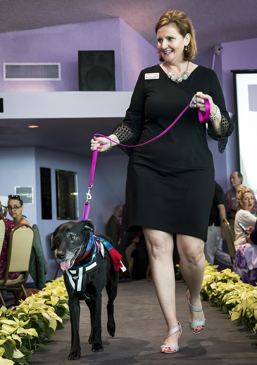 Neuro Challenge Executive Director Robyn Faucy walks the runway escorted by Bella Schwartzbaum.