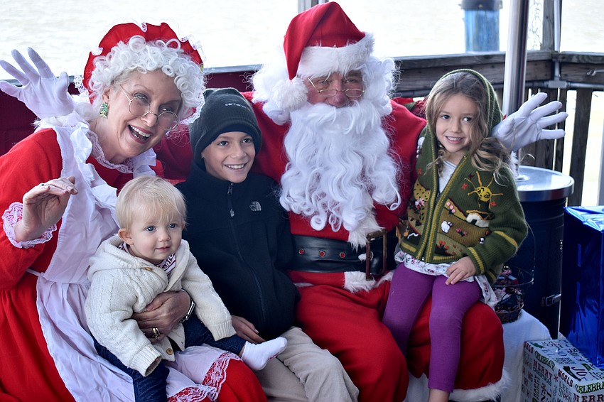 Eliza, Jackson and Marin Mitchell pose for a photo with Santa and Mrs. Claus.