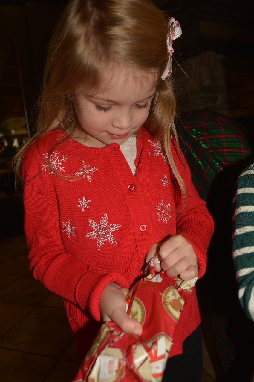 Sofia Ham, 6, opens the present she received from Santa.