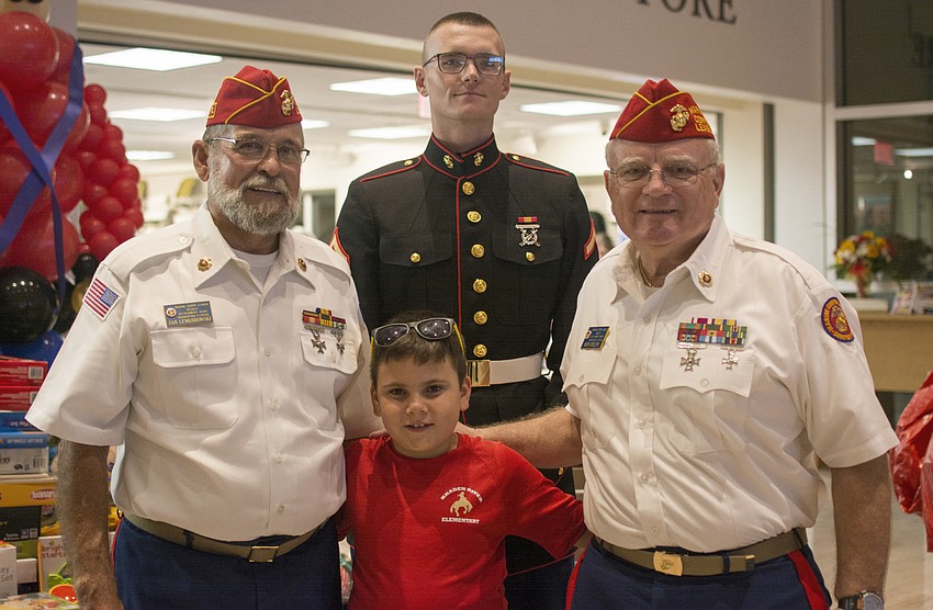 Jan Lewandowski, Collin Deaquiair, Bob Fields and Andrew Fertig pose in front of the Toys for Tots donations.