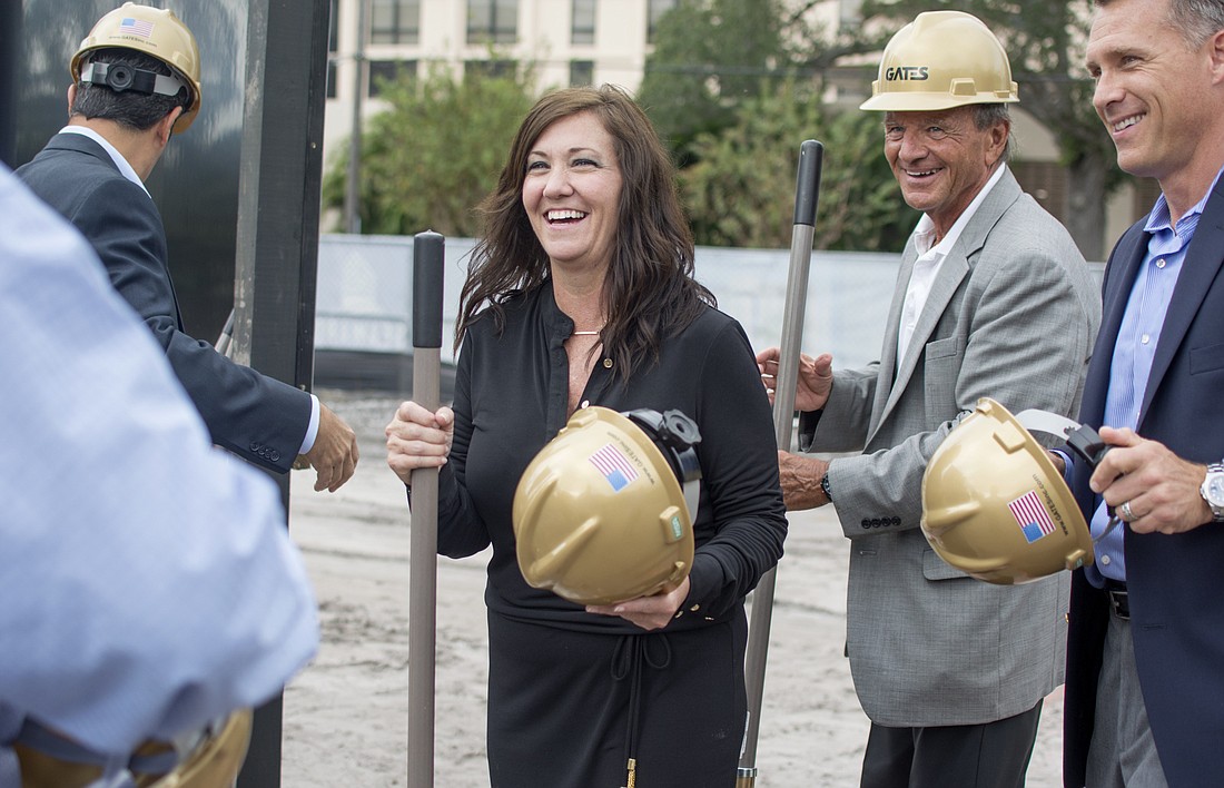 Seaward Development Vice President of Operations Anna Chesanek laughs as she puts on her gold hard hat for the groundbreaking.