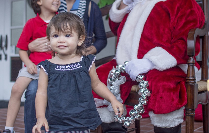 Jayden Gomez waits her turn while her brother, Phoenix Gomez, tells Santa his holiday wishes.