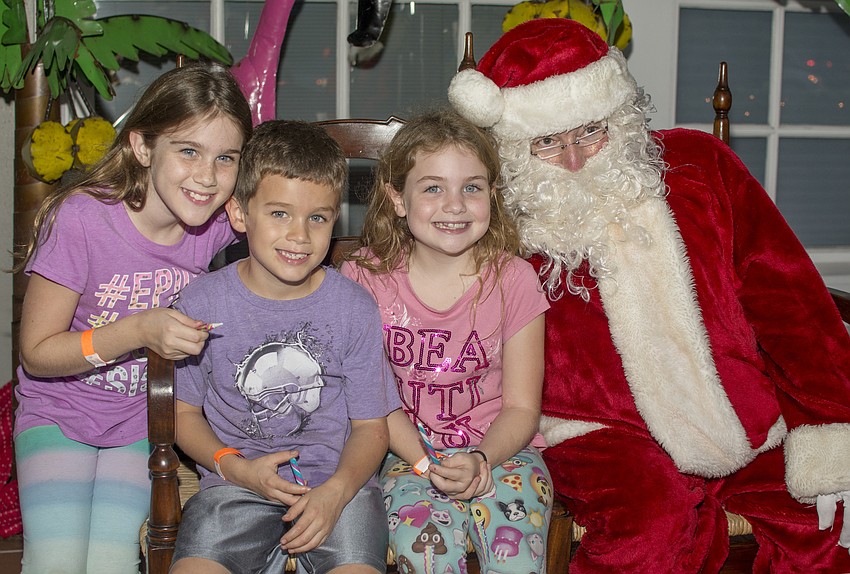 Victoria, Nicholas and Olivia Roach pose with Santa.
