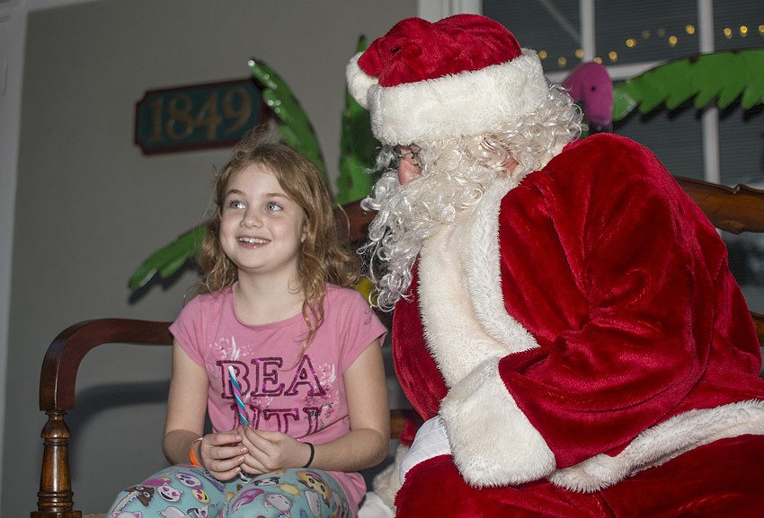 Olivia Roach tells Santa her holiday wishes during the annual Southside Village Holiday Stroll.