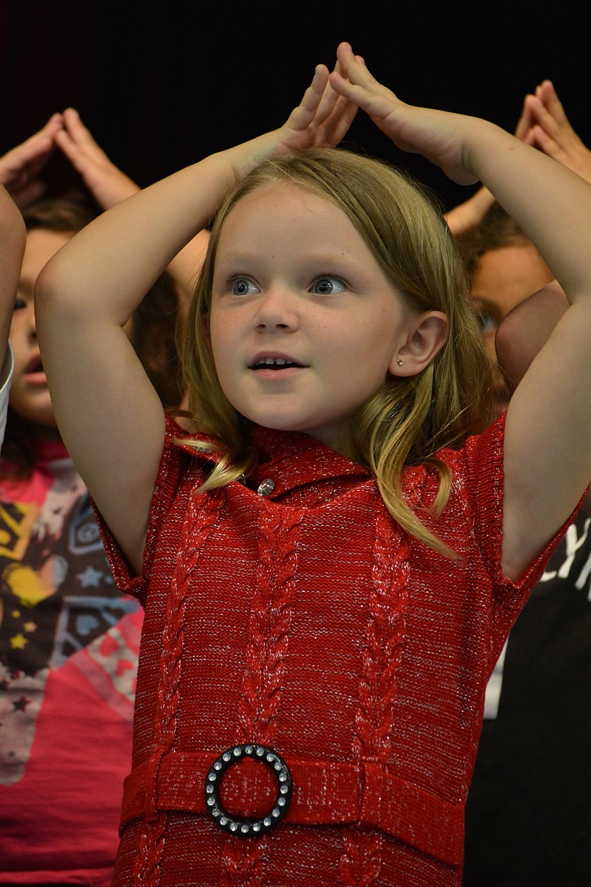 Maci Dodrill, 6, sings about Santa, who has a cherry-colored nose and hollers 