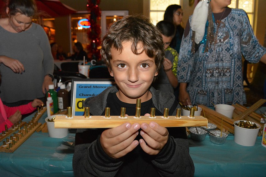 Lakewood Ranch's Alan Lopez Markov, 5, makes a menorah out of wood and bullet shell casings.