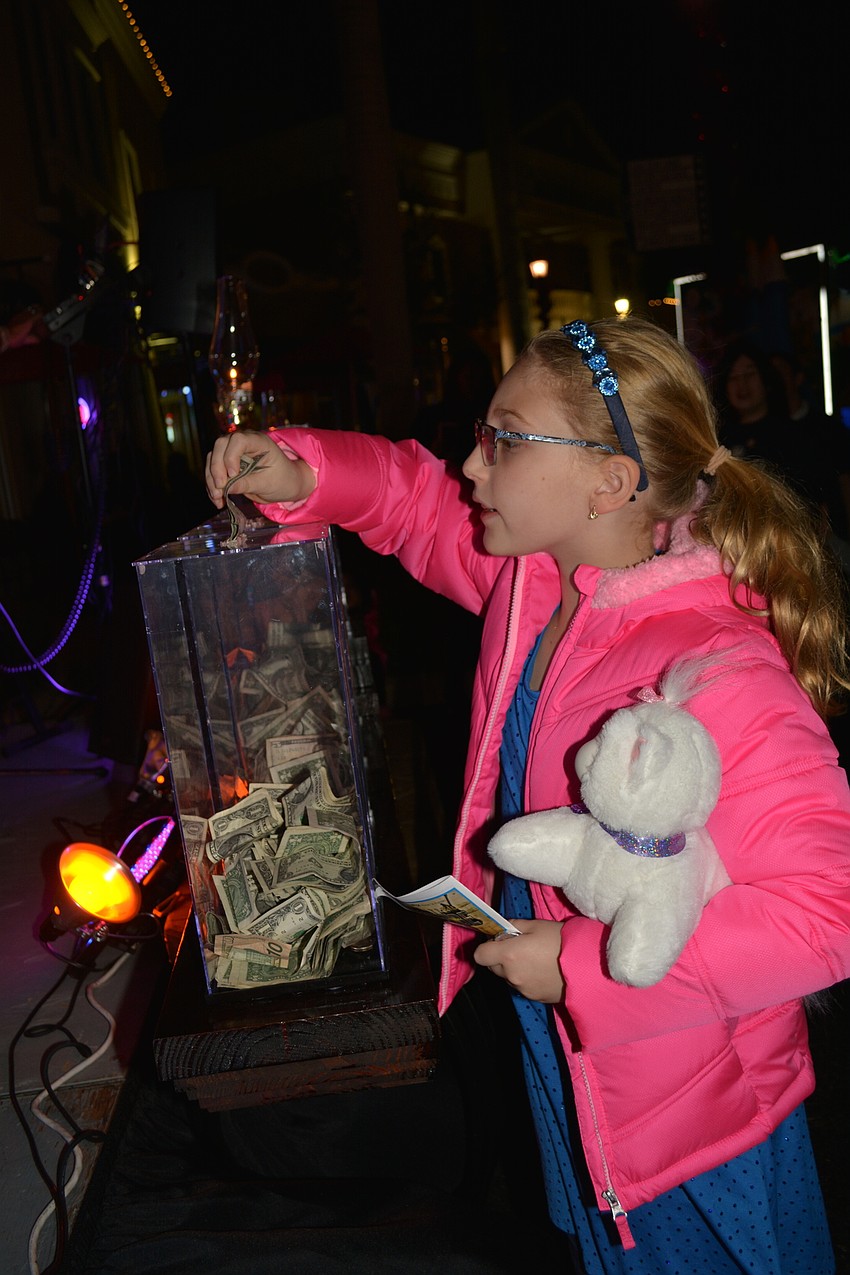 Willis Elementary School's Rachel Gocinski, 8, makes a donation to The Lone Soldier's Home Away from Home charity in Israel.