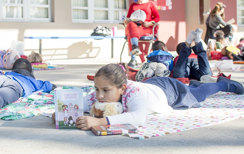 Ianna Guedes joins fellow students with a book.