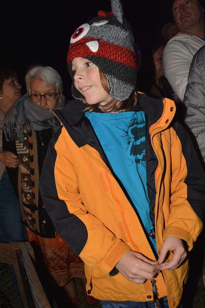 East County's Bryce Albritton, 9, watches a woman cooking chicken legs .