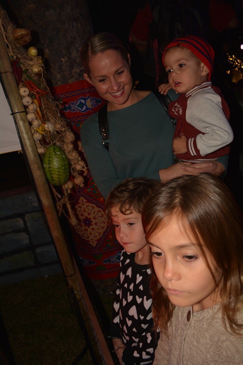 Krystle Sommers, of Lakewood Ranch, used the night to teach her children —Annabelle (front), Evelyn (center) and Elliott (being held) — about each scene.