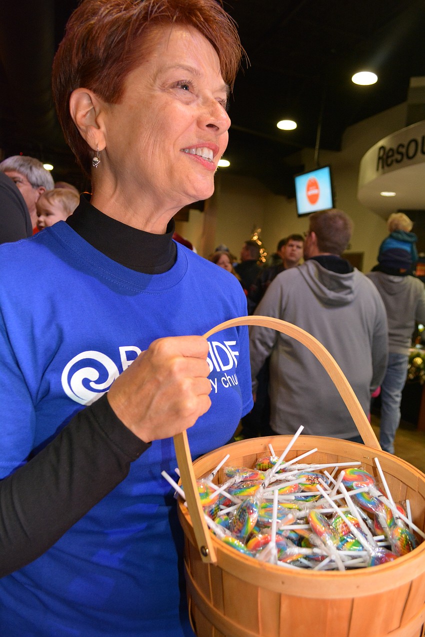Bayside volunteer Debra Pedrow passes out colorful lollipops.