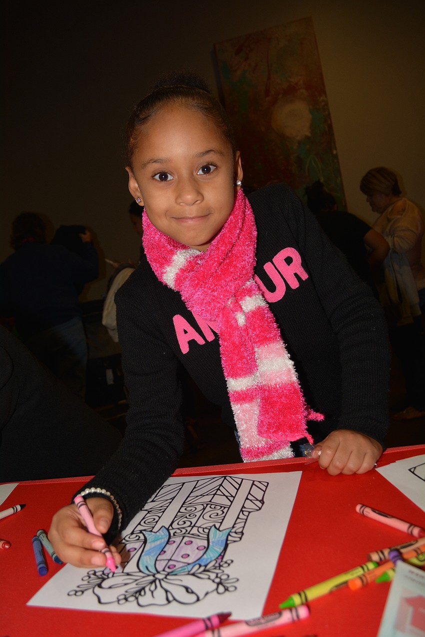 Bayside member Xia Cody, 7, colors a picture of presents.