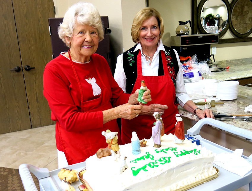 Patty Buck and Diane Neely decorate a birthday cake for Jesus. Photo by Vivian Chester.