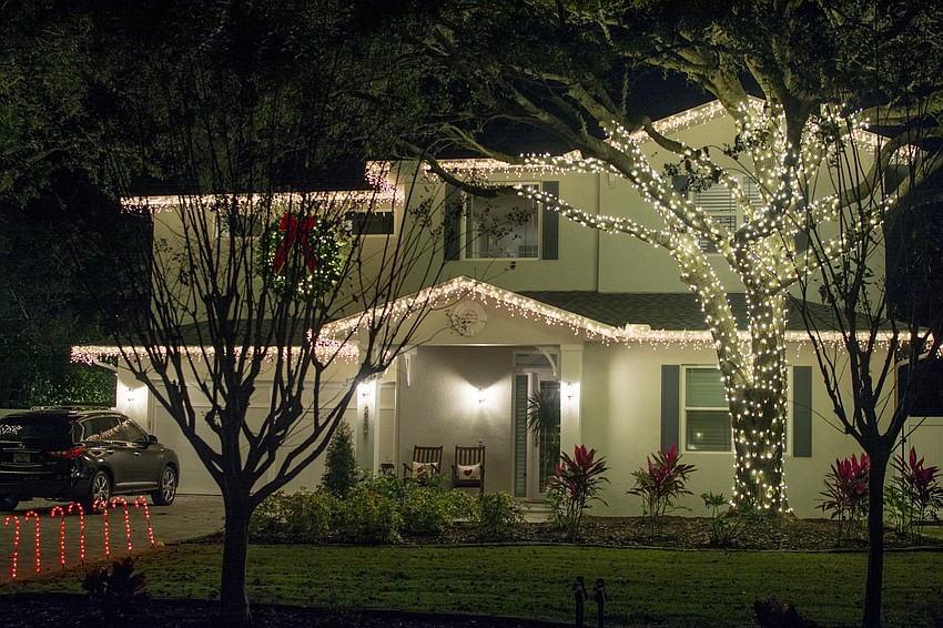2207 Wisteria Street glows amidst its classic, white lights.