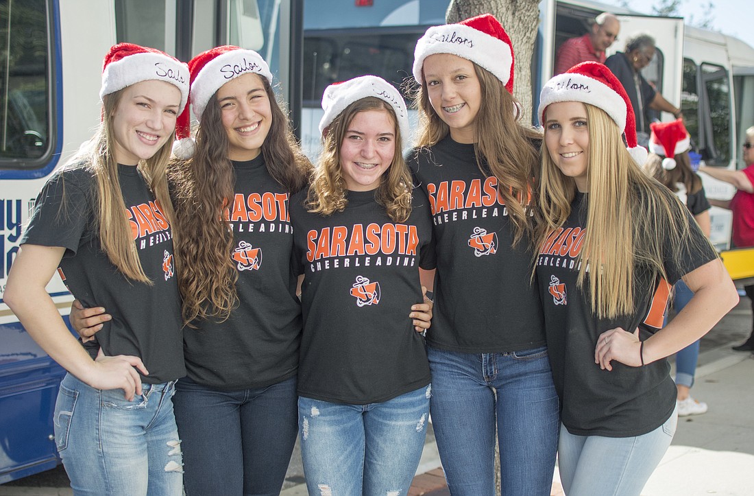Sarasota High School cheerleaders assist senior care facility residents find their seats at a special showing of the Singing Tree.
