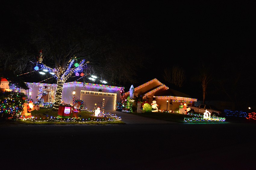 Owners of 6443 and 6447 Golden Leaf Court both lined the tops of their respective roves with colored lights and white icicle lights along the lower roofline. (Photo by Pam Eubanks).