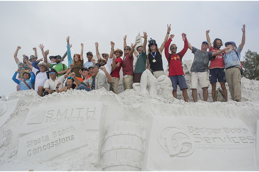 Crystal Classic International Sand Sculpting Festival sculptors pose for a photo near the entrance of the festival.