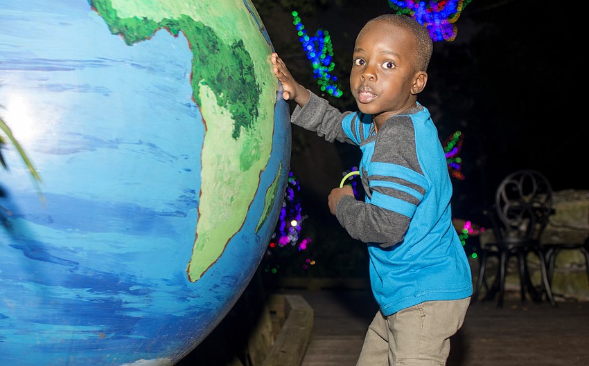 Akim Mukarage spins the globe outside the Ann Goldstein Children Rainforest Garden at Selby Gardens.