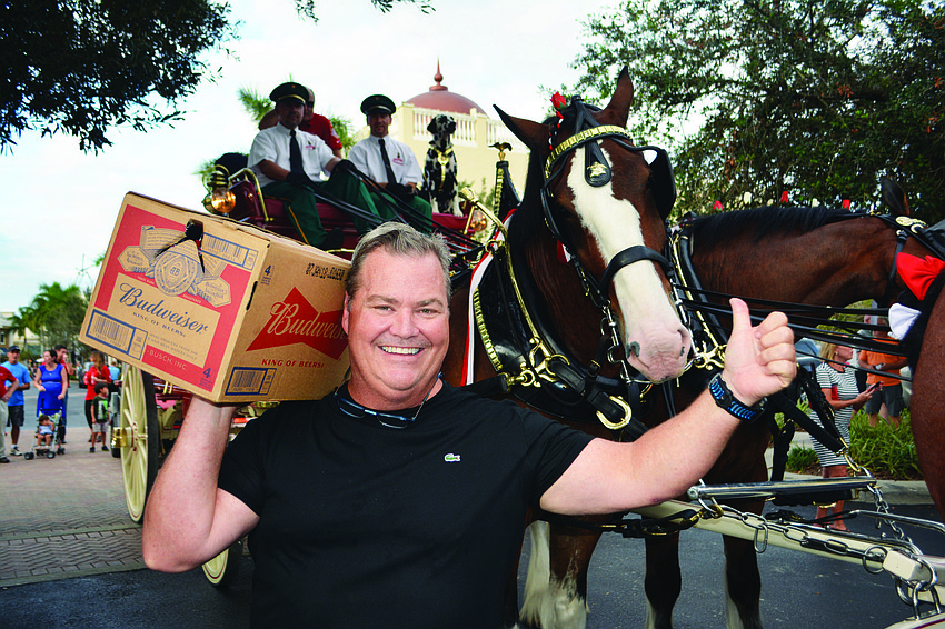 Tommy Klauber of the Polo Grill and Bar gets a free case of Budweiser from a wagon pulled by the famous Clydesdales on Lakewood Ranch Main Street Oct. 12.