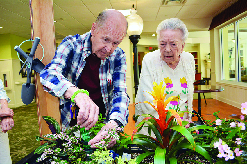 Windsor Reflections residents Bob Barton and Mary Sue Hudgens work with plants Aug. 10.